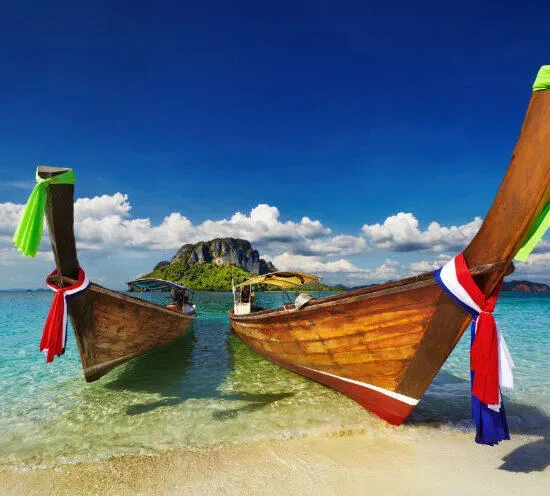 Deux bateaux traditionnels longtail amarrés sur une plage paradisiaque