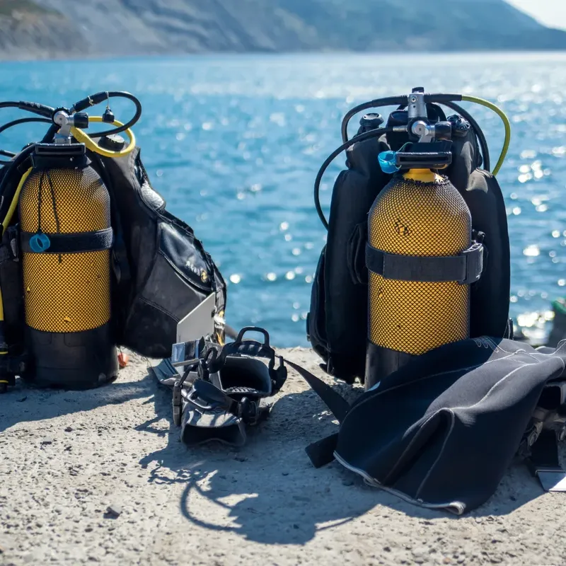 Equipement de plongée sur une surface sableuse avec la mer en arrière-plan