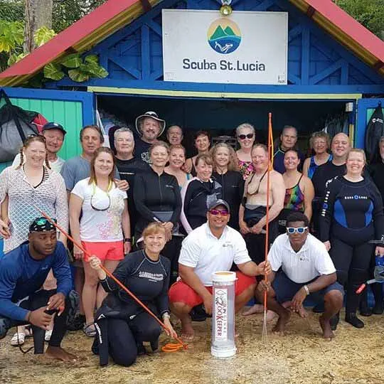 Groupe de plongeurs souriants devant le centre de plongée tropical