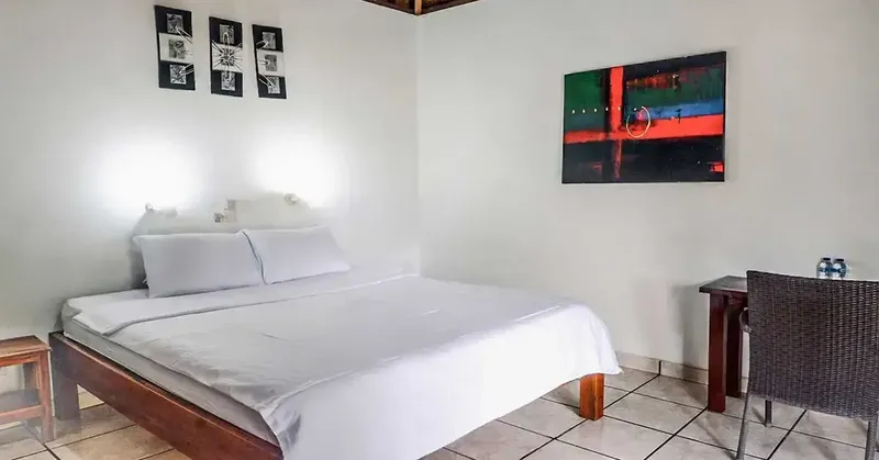 Chambre simple avec un lit double, une table de chevet et un bureau
