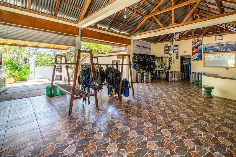 Local de plongée spacieux avec équipement, bouteilles et comptoir d'accueil