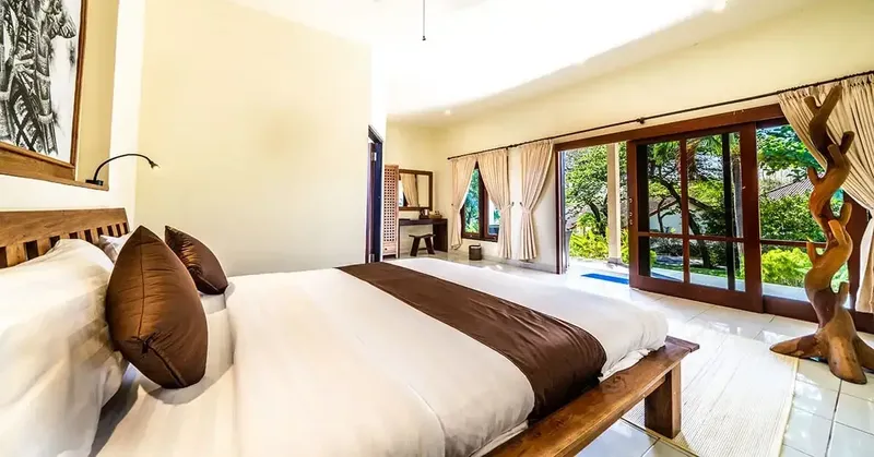 Chambre d'hôtel lumineuse avec lit double et vue sur jardin tropical
