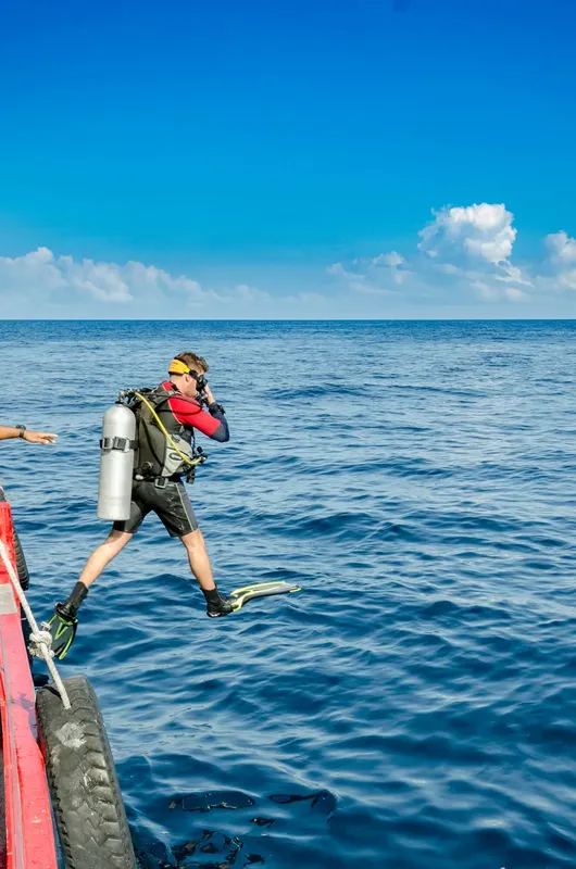 Plongeur s'apprête à sauter d'un bateau en pleine mer