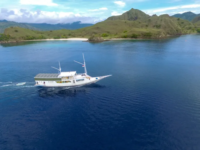 Bateau de plongée navigue sur une mer bleue devant des îles