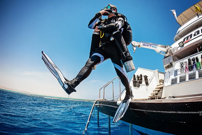 Plongeur s'apprête à sauter d'un bateau de plongée en pleine mer