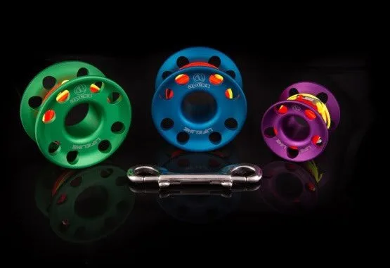 Bobines de fil et mousqueton en aluminium coloré sur fond noir