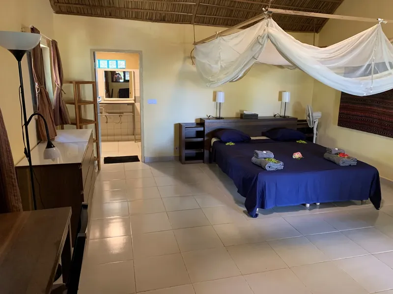 Chambre d'hôtel avec lit à baldaquin et mobilier en bois clair