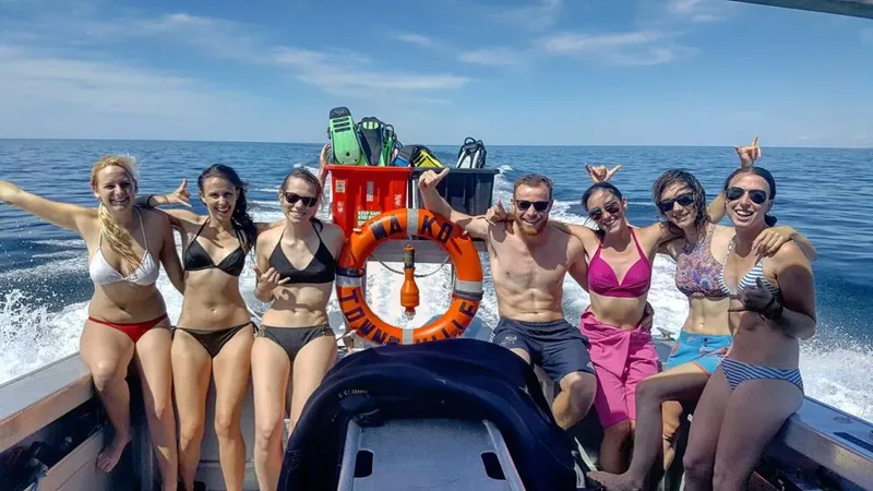 Groupe de personnes souriantes à bord d'un bateau de plongée en mer