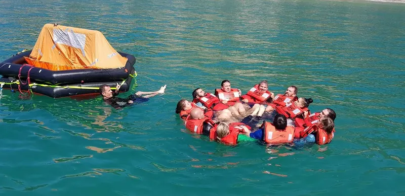 Groupe de personnes en gilets de sauvetage flottant dans l'eau