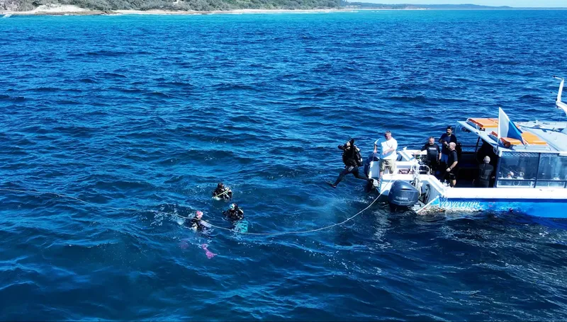 Plongeurs s'apprêtent à entrer dans l'eau depuis un bateau de plongée