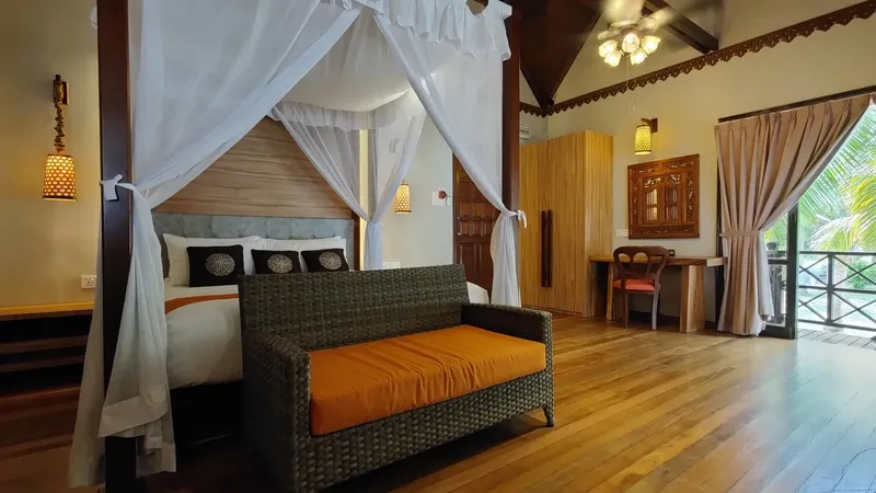 Chambre d'hôtel avec lit à baldaquin et mobilier en rotin