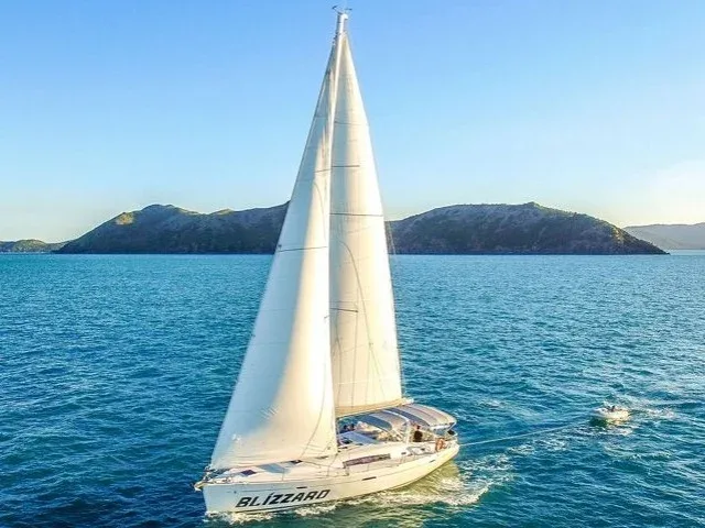 Voilier blanc naviguant sur une mer bleue avec des passagers à bord