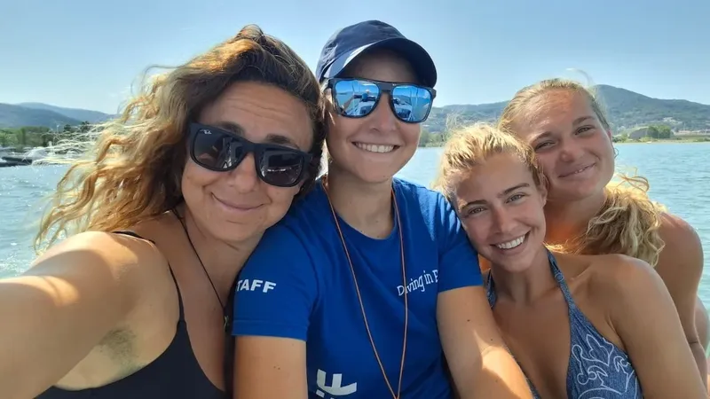 Quatre personnes souriantes sur un bateau en mer, journée ensoleillée