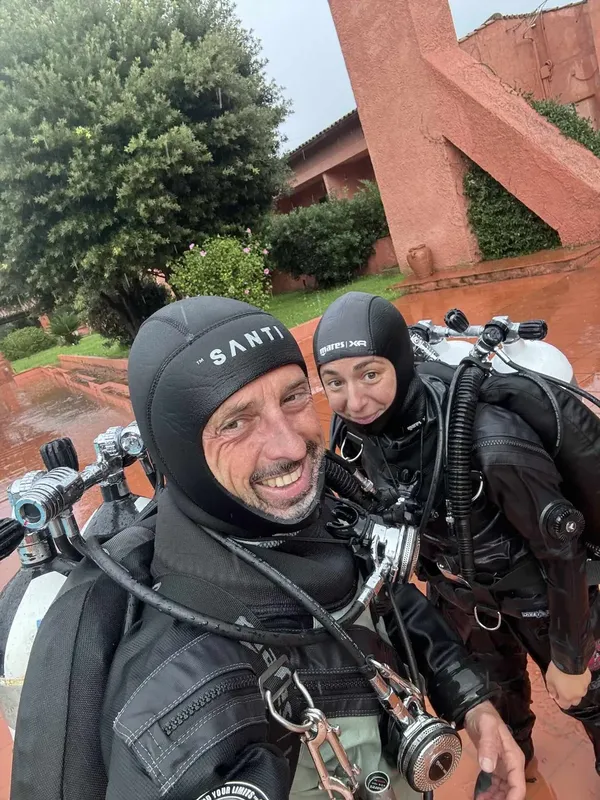 Deux plongeurs souriants en équipement complet posent pour un selfie