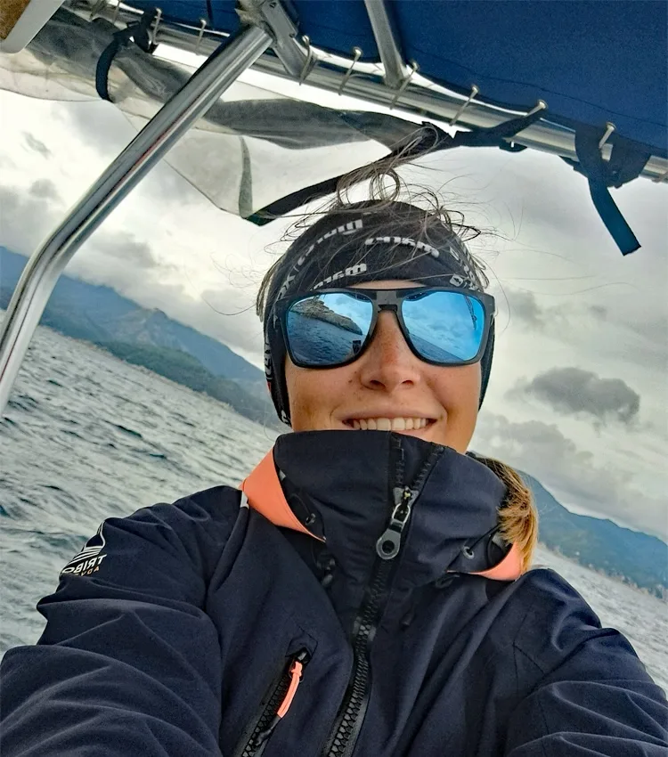 Femme souriante avec lunettes de soleil sur un bateau en mer