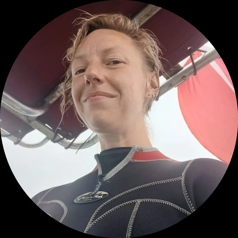 Portrait d'une plongeuse souriante avec combinaison et cheveux mouillés