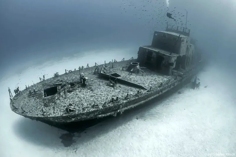 Épave de bateau coulé, recouverte de sédiments, vue sous-marine floue