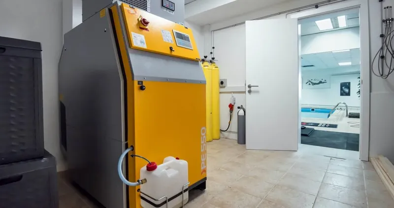 Compresseur de plongée jaune et équipements dans un local technique clair