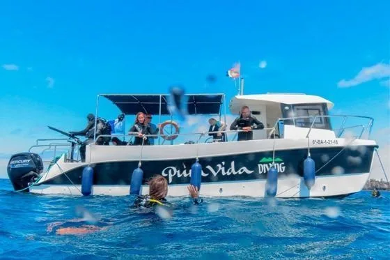 Bateau de plongée avec des personnes à bord et un plongeur en mer