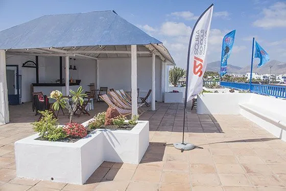 Terrasse avec espace détente, mobilier de jardin et enseignes de plongée