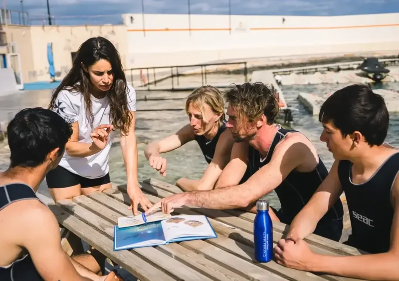 Instructrice expliquant une procédure à des élèves en maillot de bain