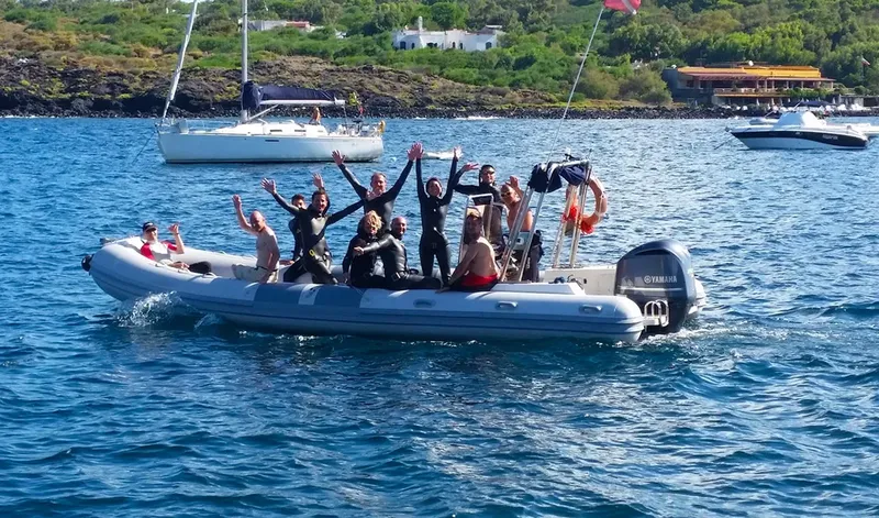 Groupe de personnes enthousiastes à bord d'un bateau semi-rigide en mer