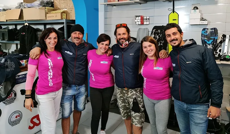 Groupe de personnes souriantes dans un magasin de plongée avec équipement