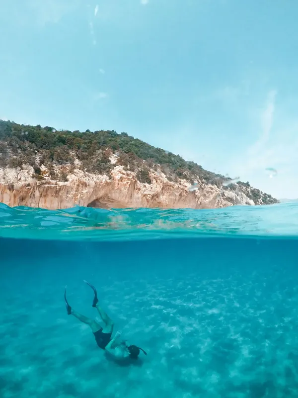 Une personne nageant en apnée dans une eau turquoise claire