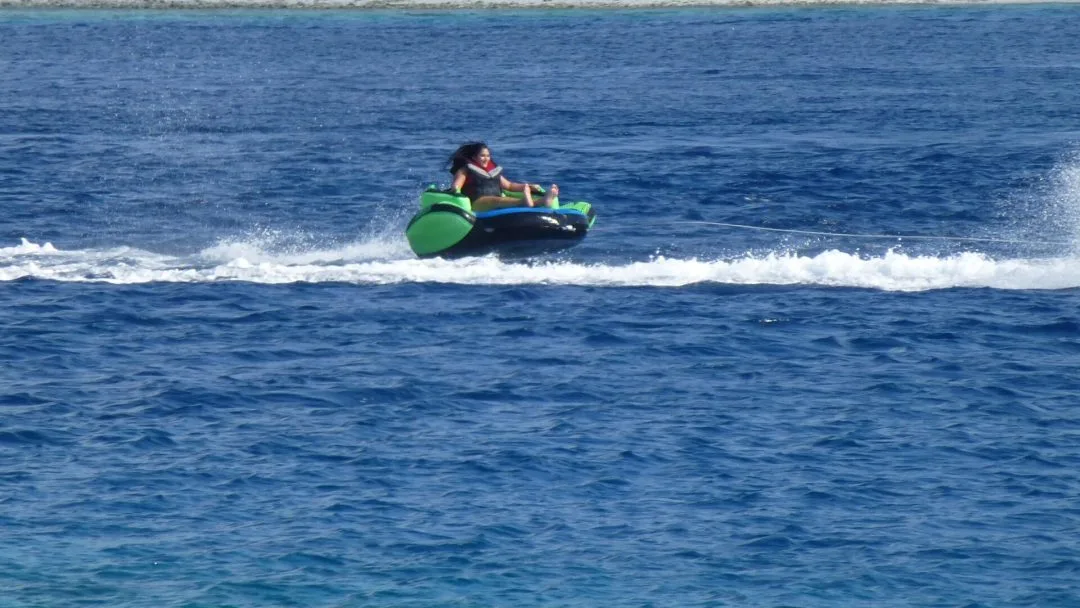 Personne tractée sur un bouée gonflable en pleine mer, activité nautique