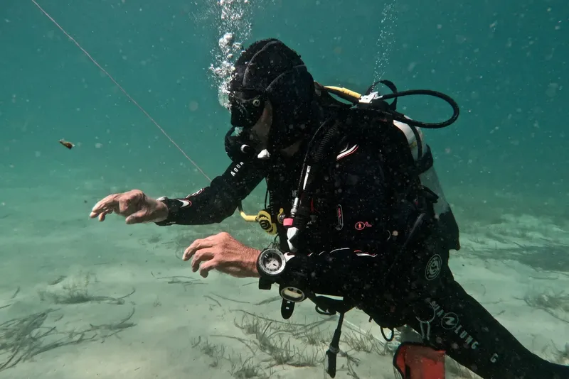 Plongeur en combinaison explore les fonds marins avec son équipement