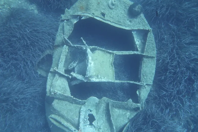 Epave de bateau rouillé, structure métallique visible sous l'eau