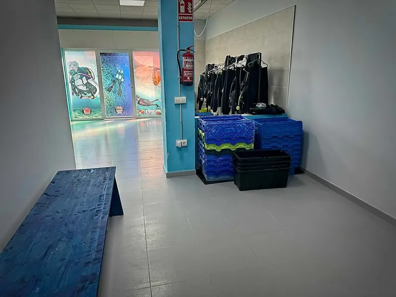 Intérieur d'un centre de plongée avec combinaisons et affiches marines