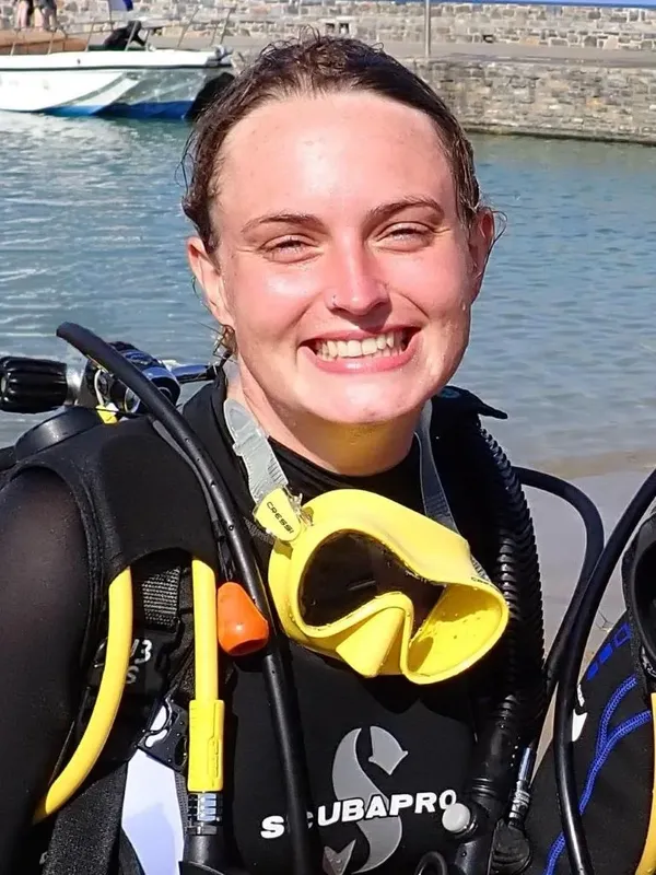 Plongeuse souriante avec masque et équipement complet prête à plonger