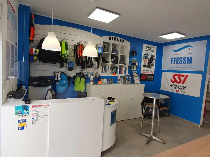 Intérieur d'un centre de plongée avec comptoir, matériel et affiches