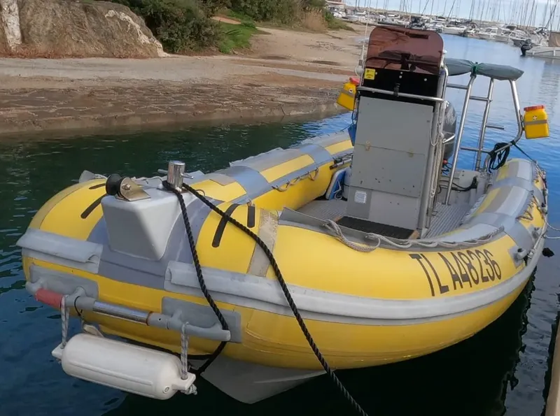 Bateau pneumatique jaune amarré dans un port ensoleillé