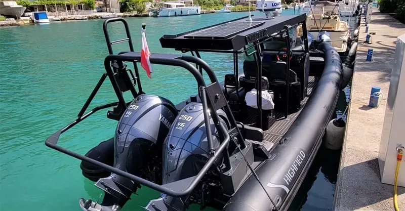 Bateau semi-rigide amarré dans un port ensoleillé avec deux moteurs