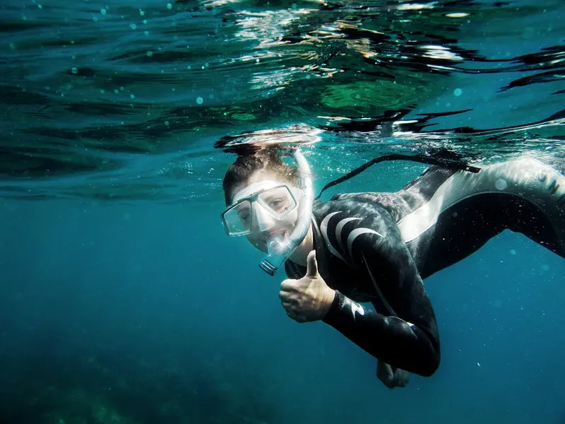 Plongeur avec masque et tuba donne un signe de satisfaction sous l'eau