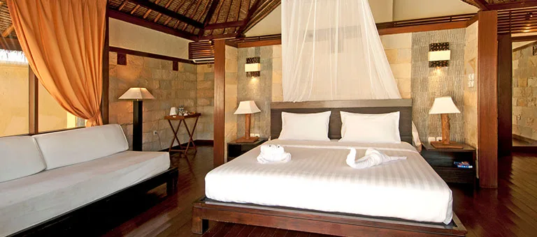 Chambre d'hôtel luxueuse avec lit à baldaquin et canapé blanc