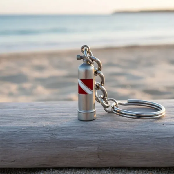Porte-clés en forme de bouteille de plongée sur du bois face à la mer