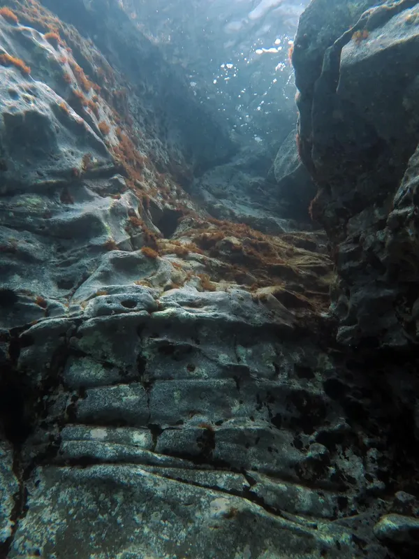 Fissure rocheuse sous-marine, lumière filtrant à travers l'eau, géologie