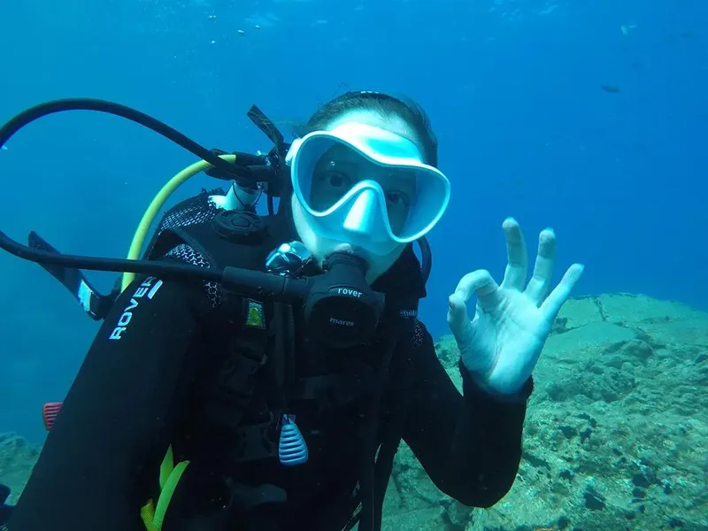 Plongeuse souriante sous l'eau, faisant un signe de validation