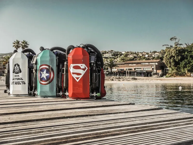 Bouteilles de plongée décorées de logos de super-héros sur un ponton