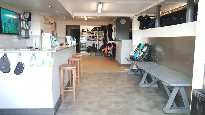 Interieur d'un centre de plongee avec comptoir, equipement et bancs