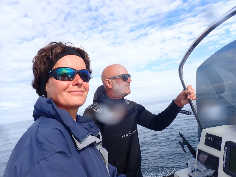 Deux plongeurs souriants à bord d'un bateau en mer
