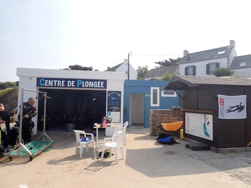 Devanture d'un centre de plongée avec du matériel et des plongeurs