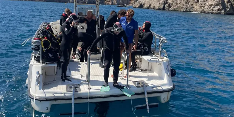 Plongeurs en équipement complet se préparent à plonger depuis un bateau