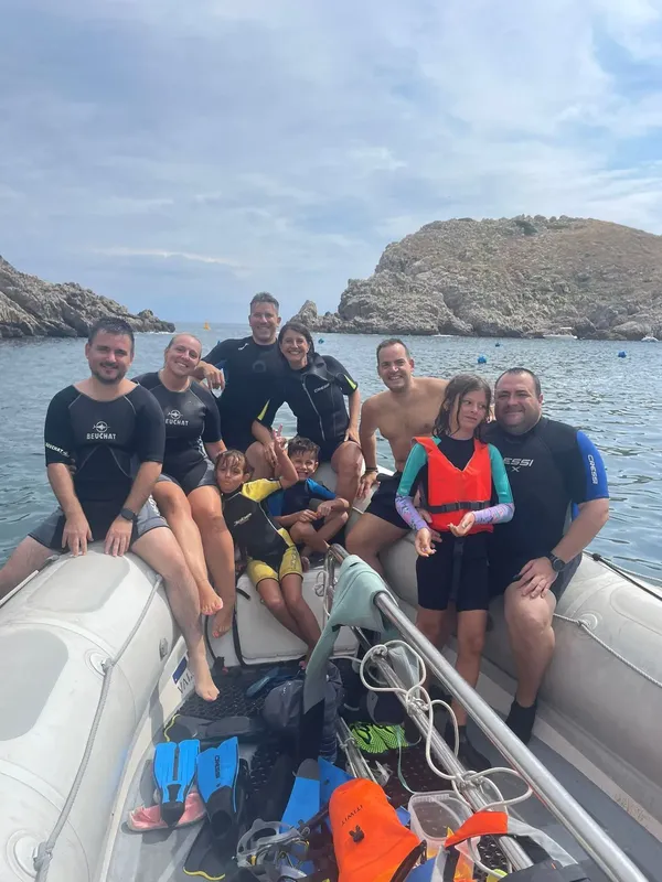 Groupe de personnes souriantes à bord d'un bateau de plongée en mer