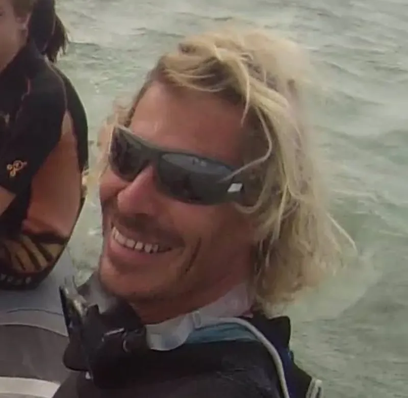 Plongeur souriant avec lunettes de soleil sur un bateau en mer