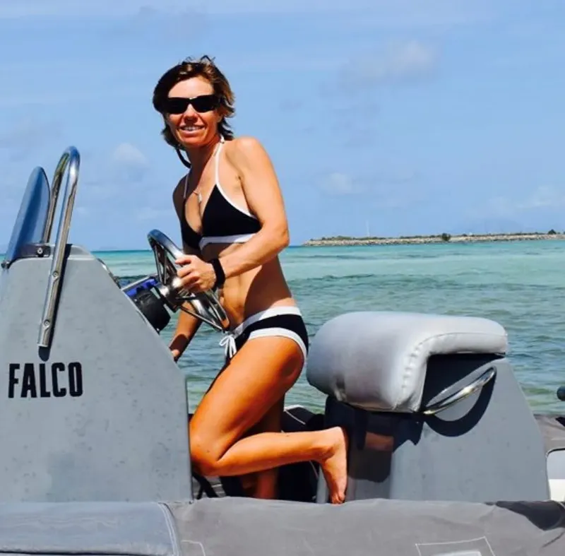 Femme souriante en maillot de bain sur un bateau semi-rigide