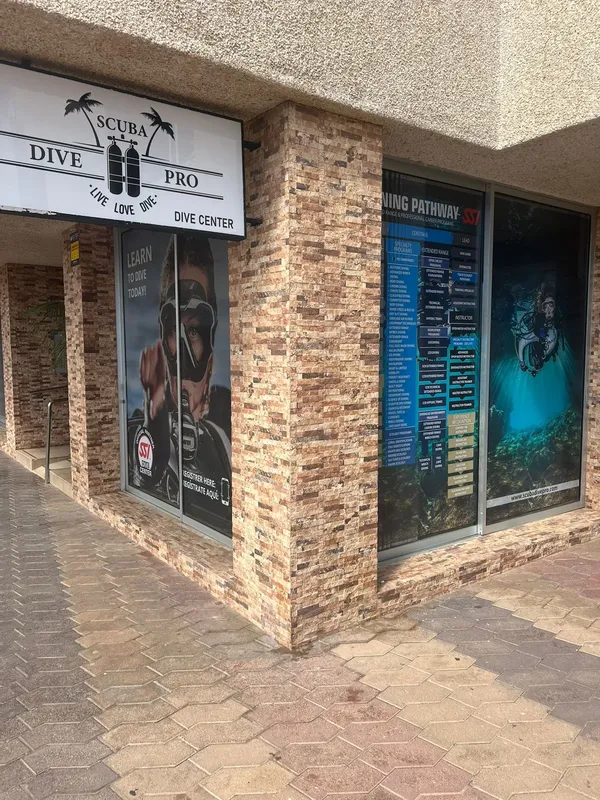 Façade d'un centre de plongée avec affiches et enseigne lumineuse